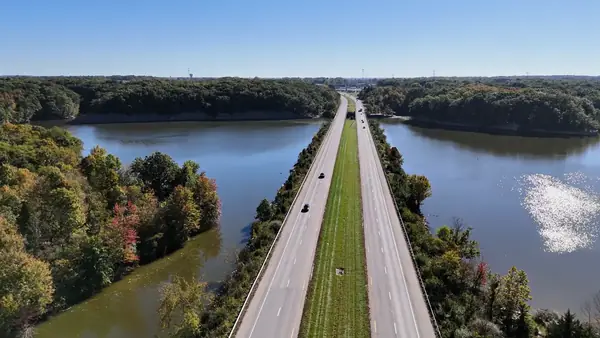 Aerial view of a divided highway crossing a reservoir between fall-colored woods in Delaware County, Ohio
